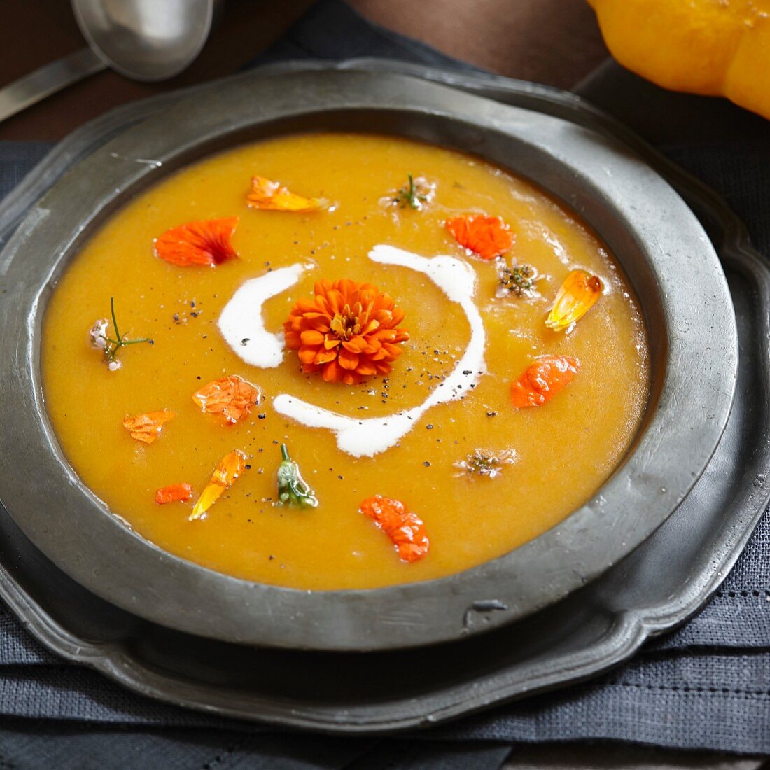 Pumpkin soup with cream and edible flowers
