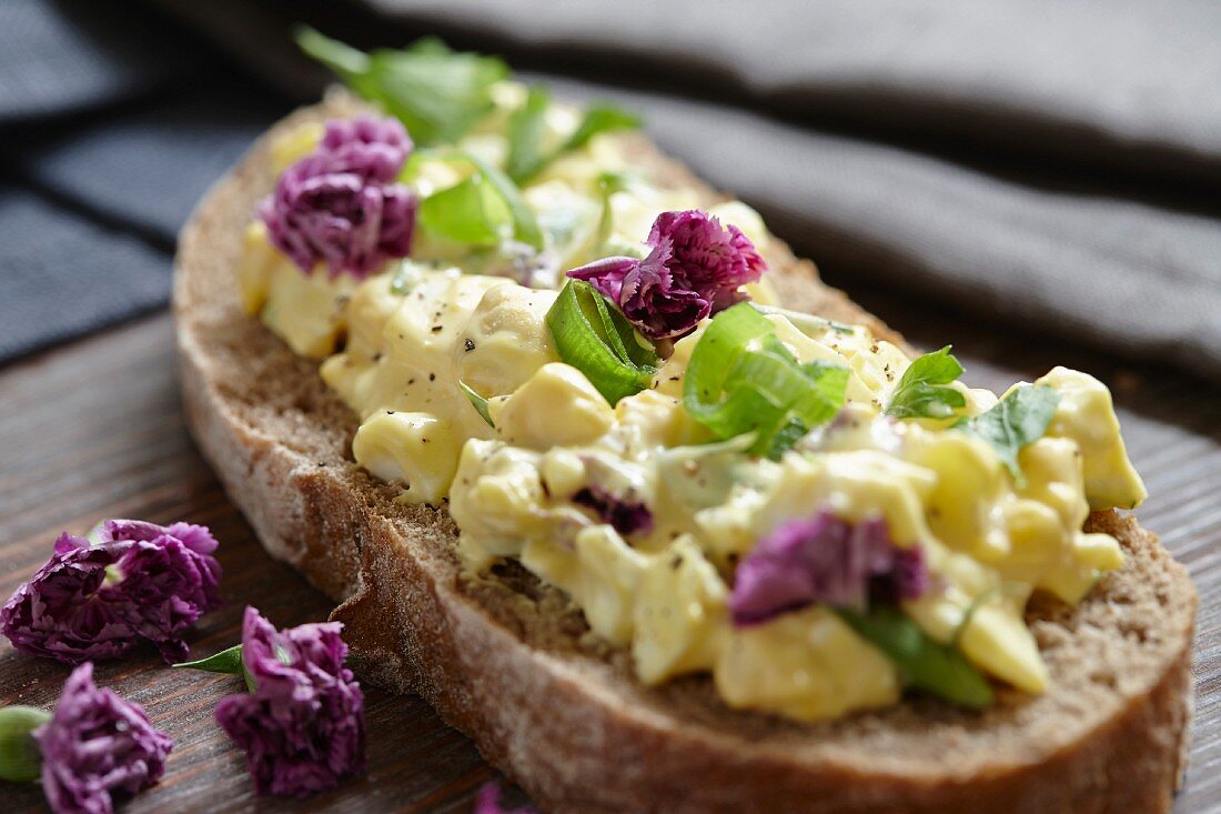 Brot mit Eiersalat und violetten Nelken