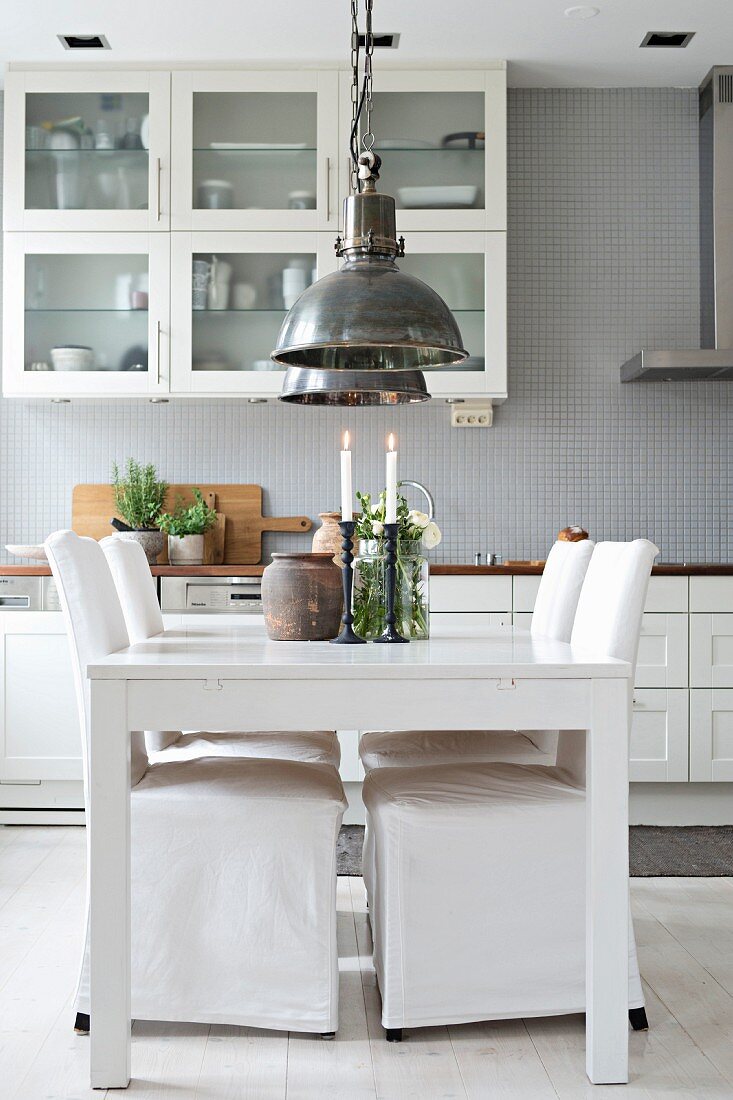 Weißer Esstisch und Stühle mit Hussen in der Küche