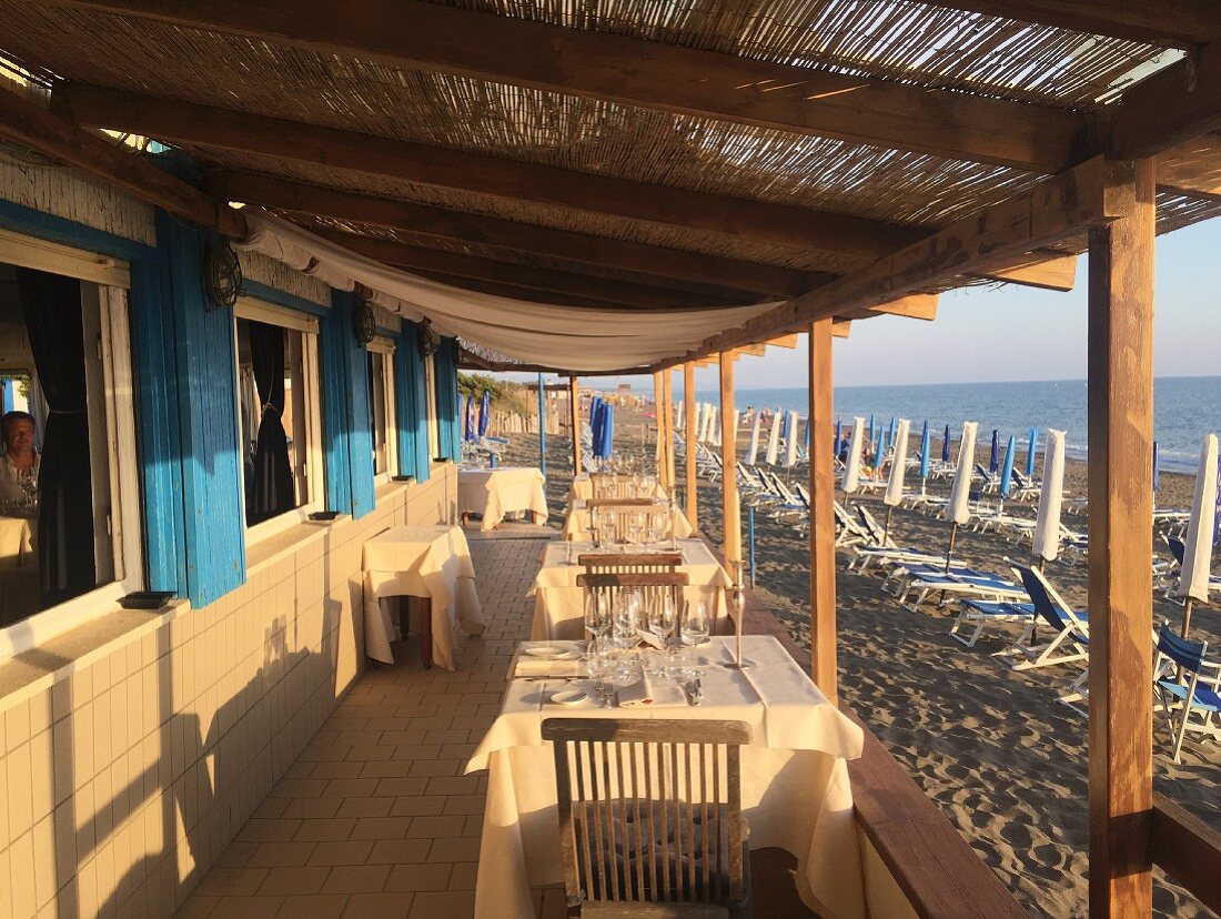 Sonnige Terrasse eines Strand-Restaurants