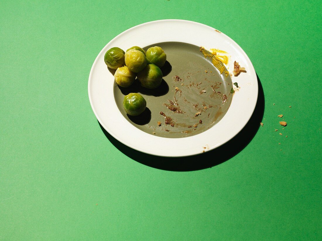 An empty plate with leftover Brussels sprouts