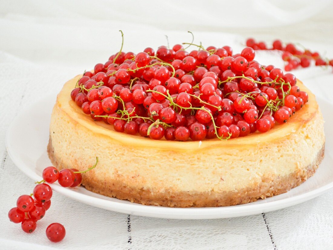 A cheesecake topped with fresh redcurrants