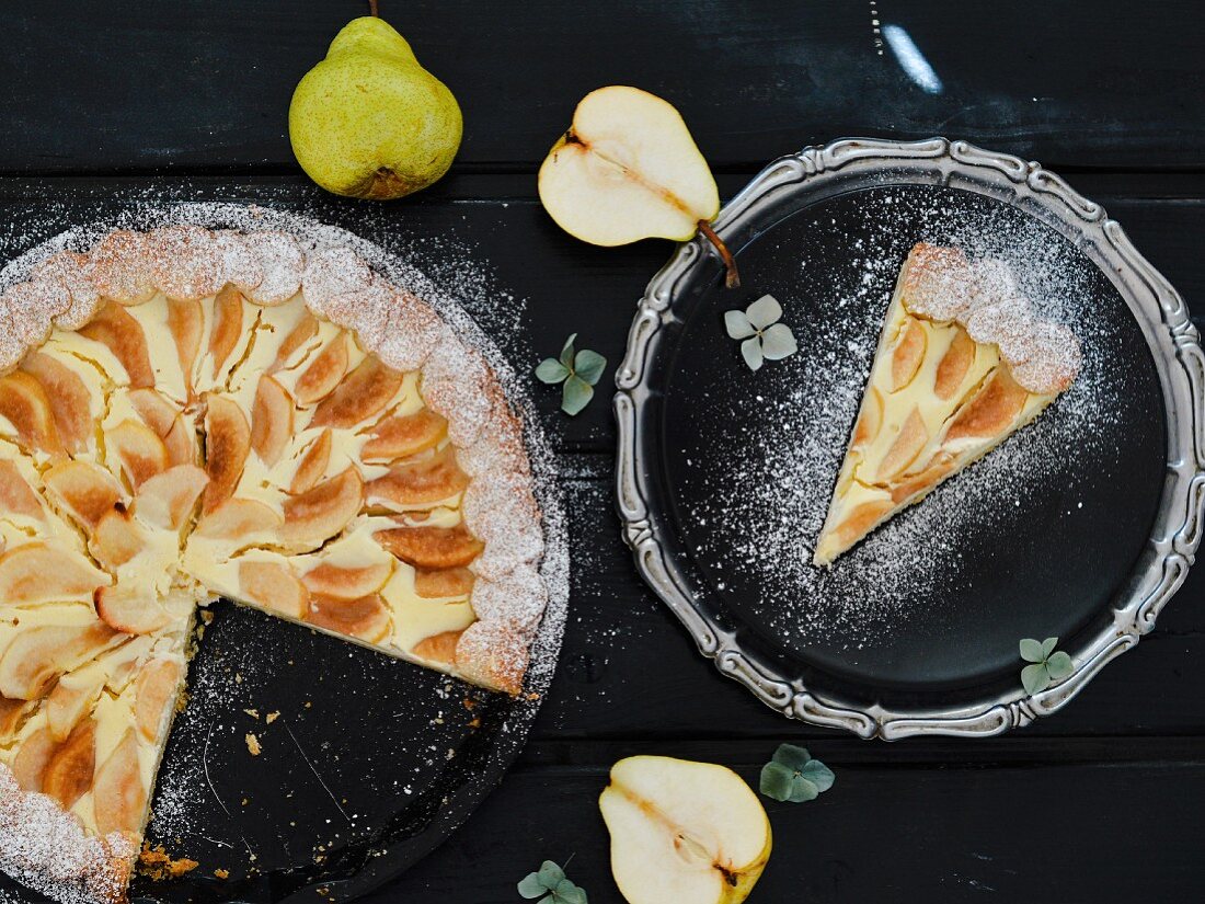 Birnen-Frischkäse-Kuchen mit Puderzucker, angeschnitten