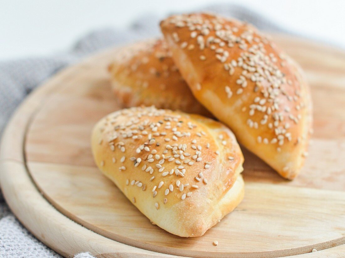 Dough stuffed with ham, cheese and pickles and sprinkled with sesame seeds