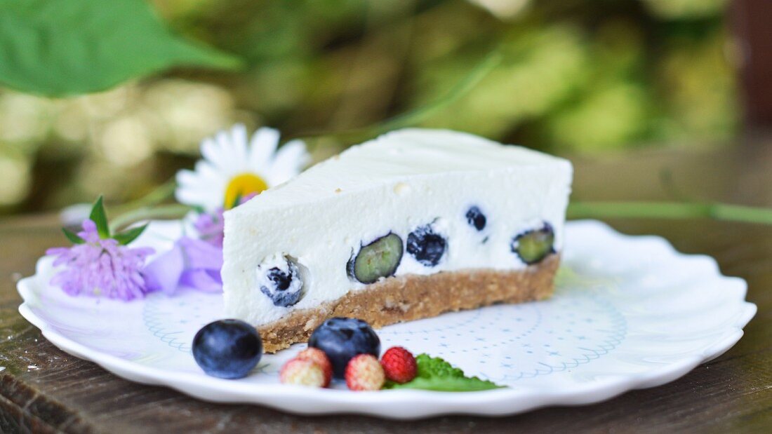 Ein Stück ungebackener Joghurtkuchen mit Heidelbeeren