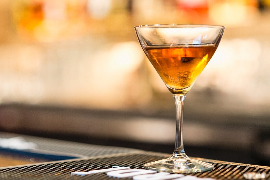A gimlet cocktail on a bar mat