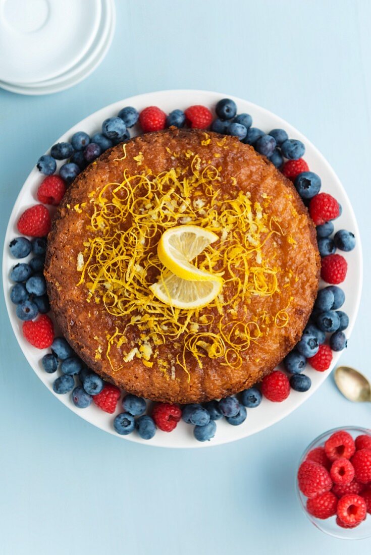 Lemon Drizzle Cake (Zitronenkuchen, England) mit Beeren dekoriert