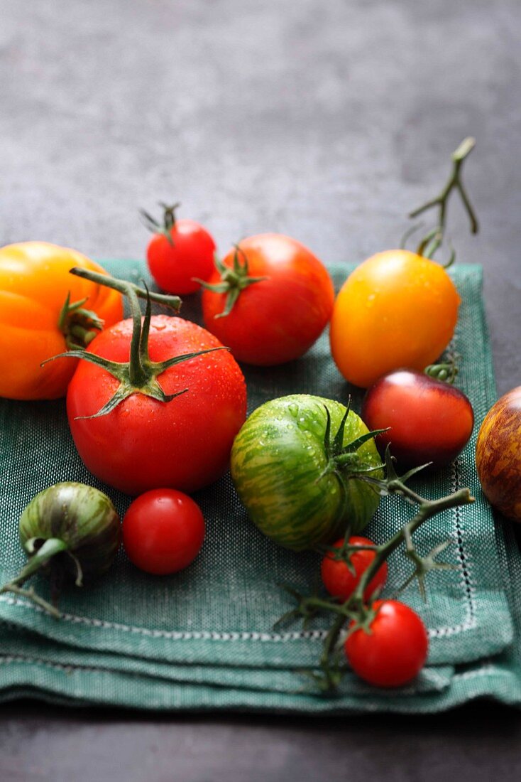 Various tomatoes lying on a cloth