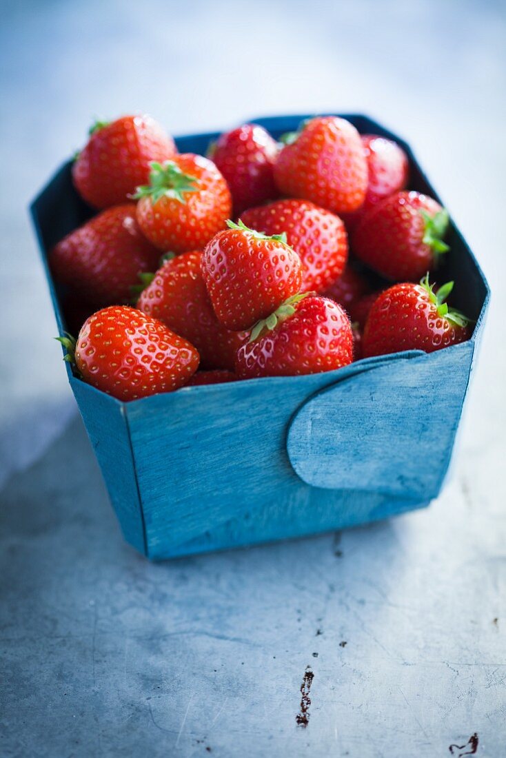 Erdbeeren in blauem Pappschälchen