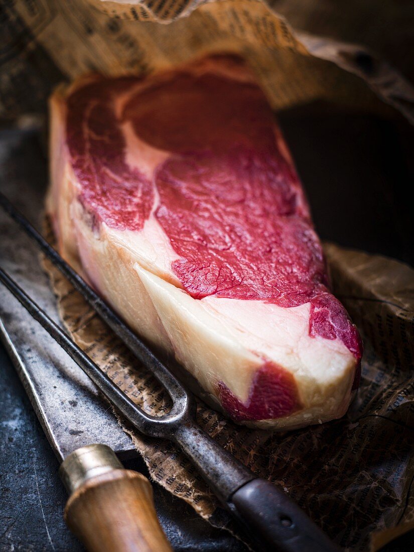 Roher Rib-Eye-Steak, Fleischgabel und Messer