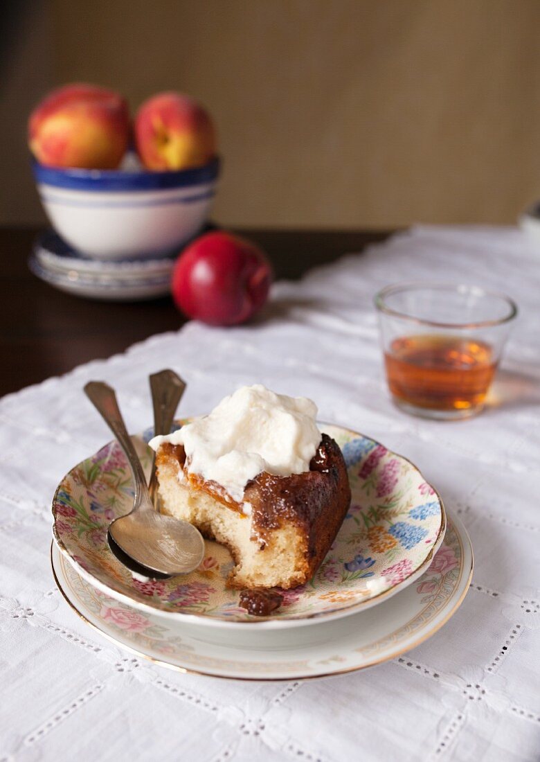 A slice of peach upside down cake with cream