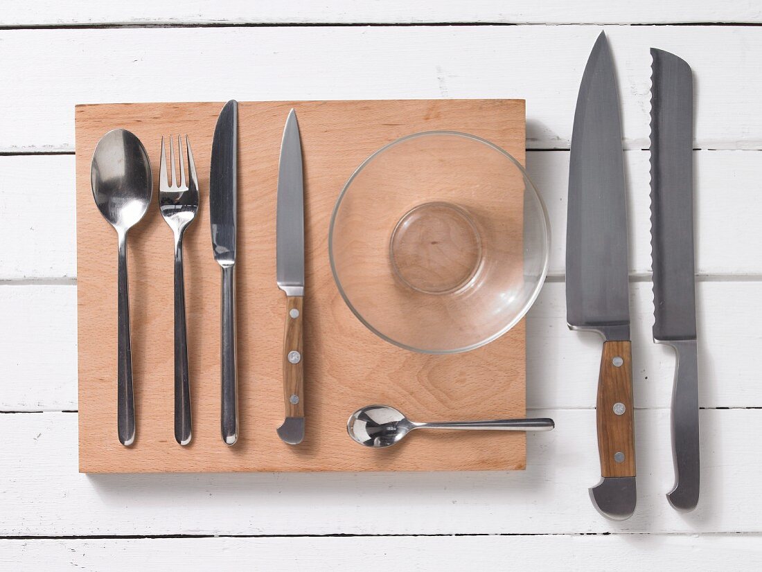 Assorted kitchen utensils: cutlery, kitchen knives and a glass bowl