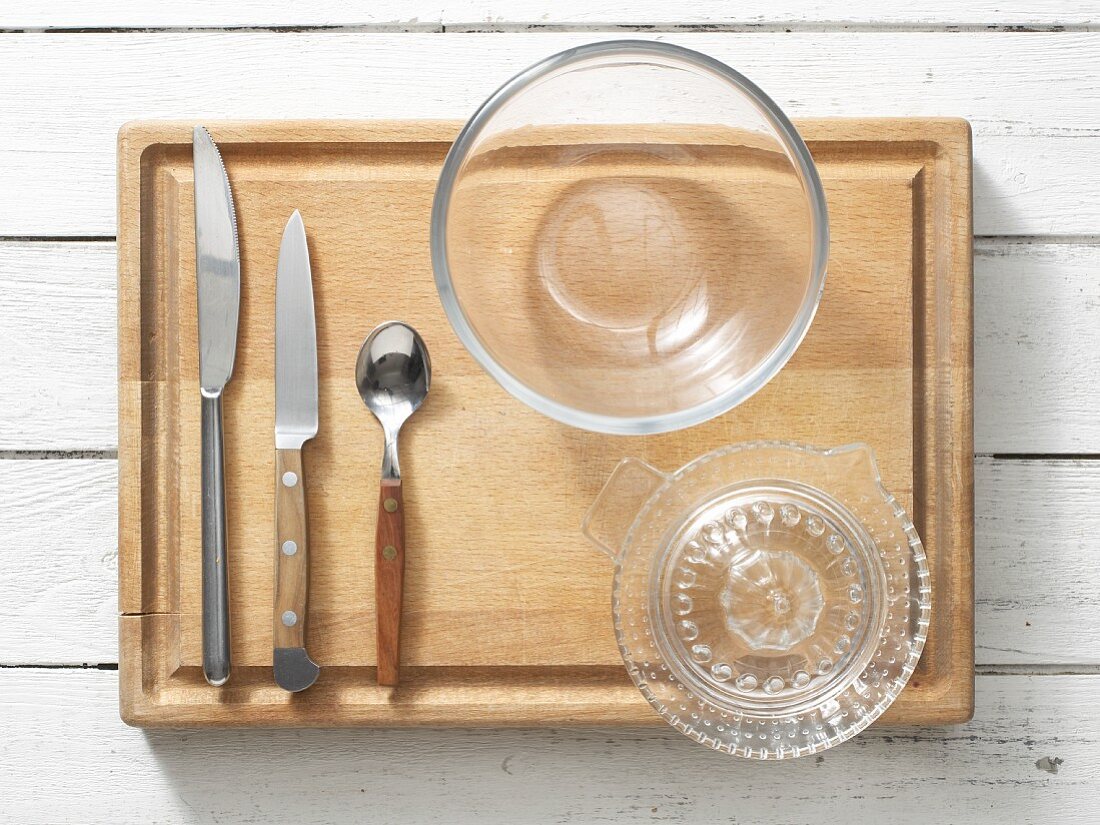 Kitchen utensils: cutlery, a citrus juicer and a glass bowl