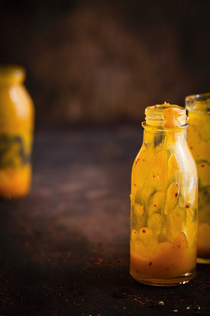 Nearly empty bottles of vegan pumpkin sauce with chilli peppers