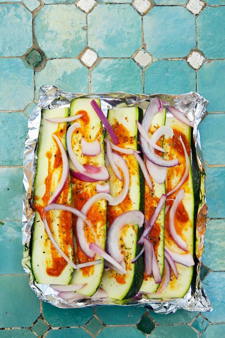 Courgettes with pesto, herbs and onions for a barbecue