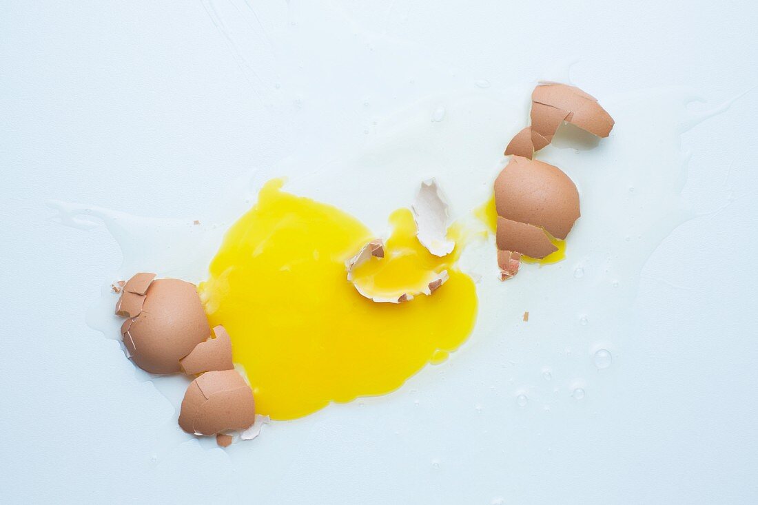 Broken eggs on a white surface