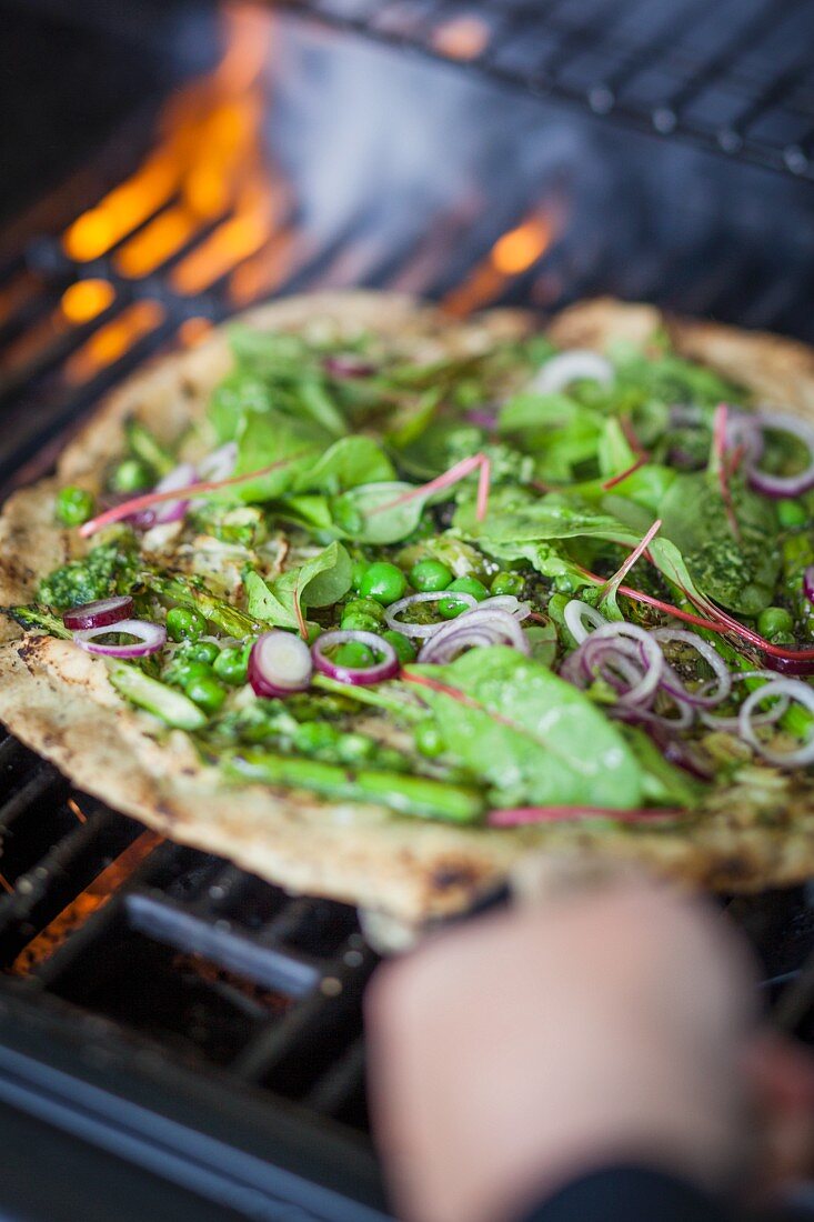 Superfood pizza with red-veined dock, peas, asparagus, and pesto