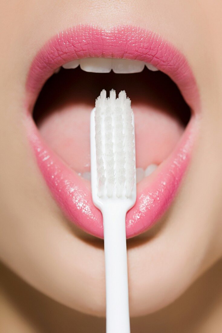 A woman's mouth with a toothbrush