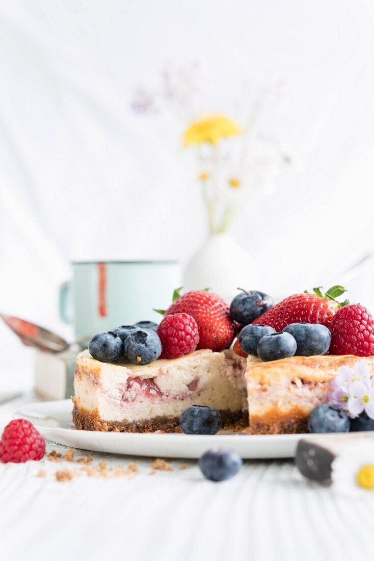 Beeren-Cheesecake mit frischen Beeren, angeschnitten