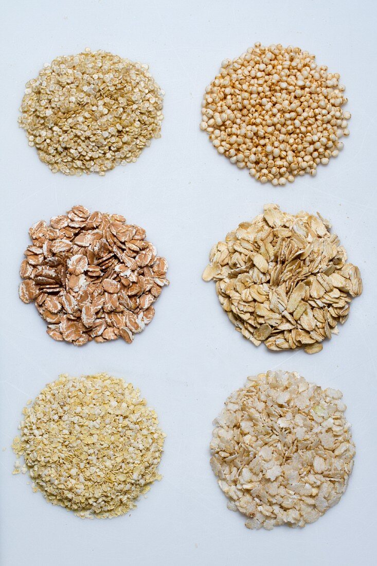 Six piles of various grains on a white surface