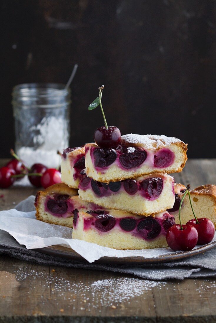 Slices of cherry tray bake cake with icing sugar