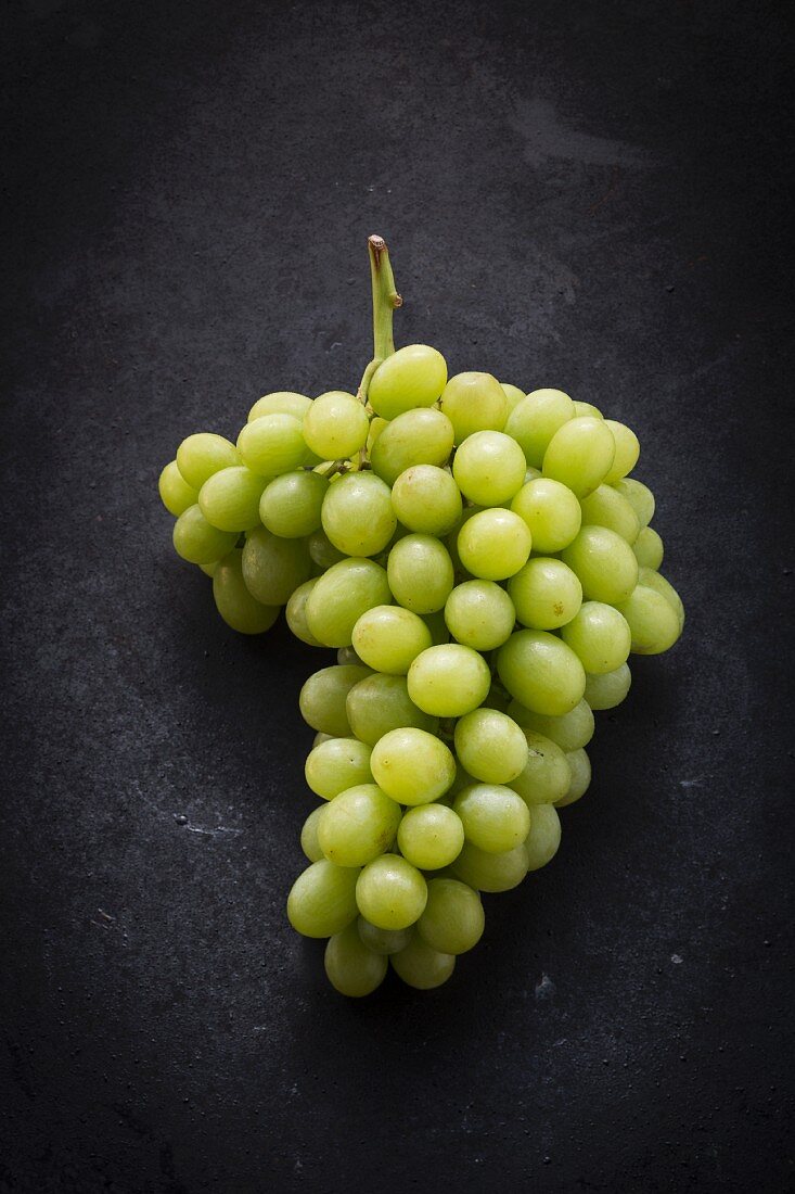 Green grapes on a black surface