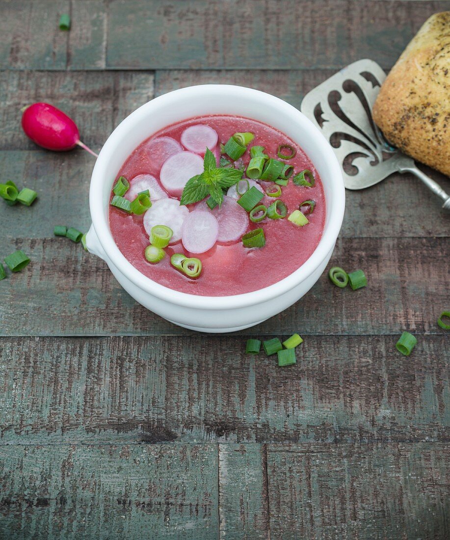 Rote-Bete-Suppe mit geschnittenen Radieschen, frischer Minze und Lauchzwiebeln