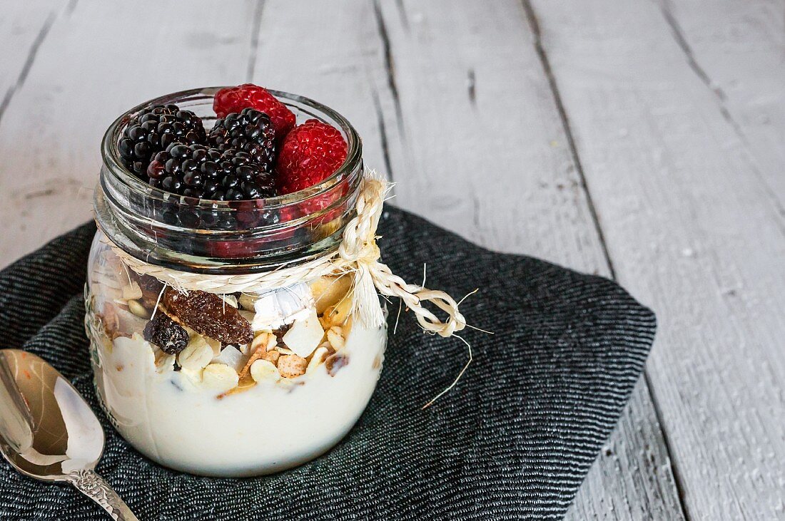 Muesli with fresh berries in a screw-top jar