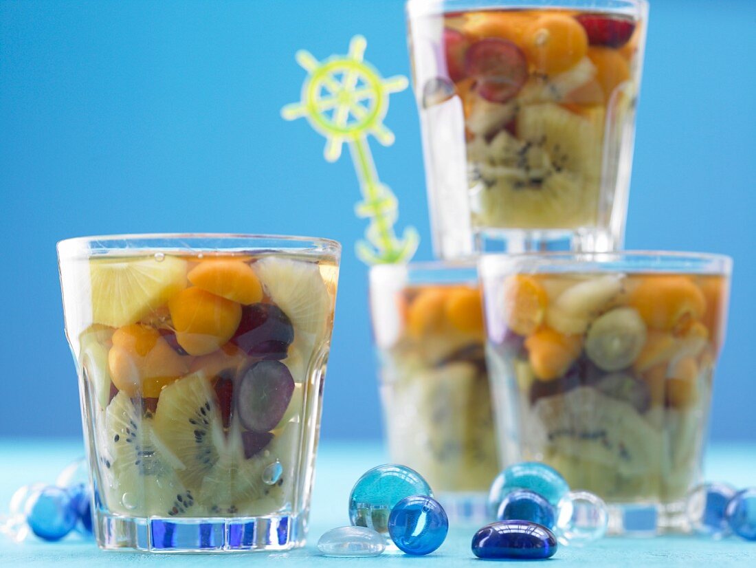Fruit jelly with kiwi, grapes, physalis and pineapple in dessert glasses