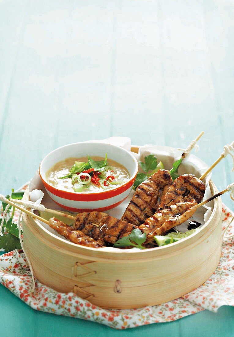 Chicken satay kebabs with hot peanut sauce, served in a steamer basket