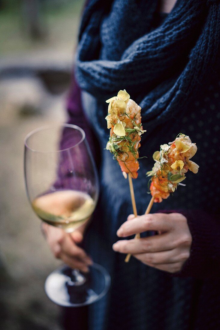 Grilled marron on a stick with citrus butter, flowers and herbs