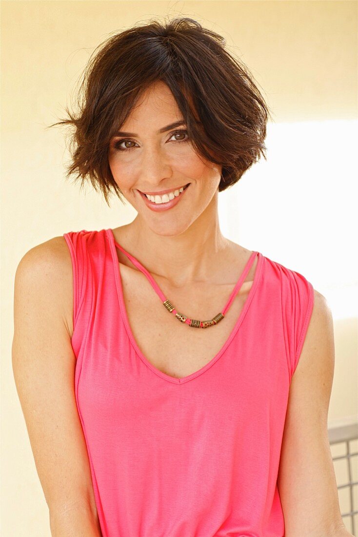 A brunette woman in a pink-coloured top