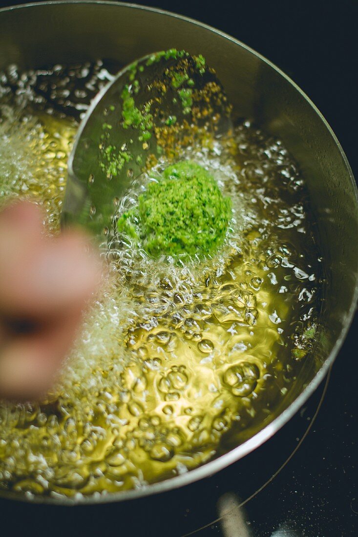 Kale falafel being fried in oil