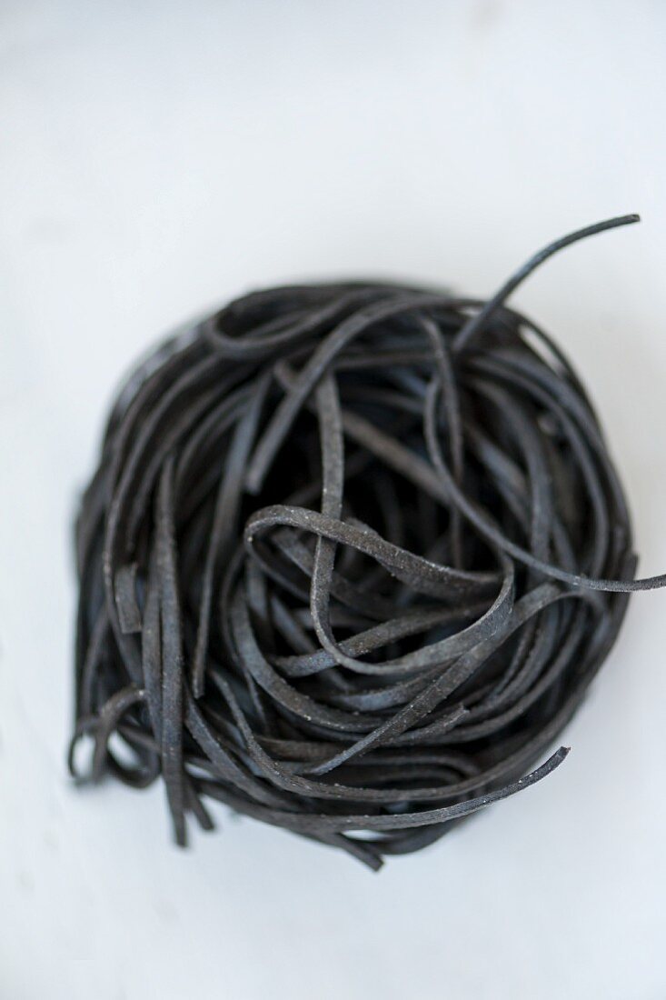 A pasta nest made of black sepia pasta (seen from above)