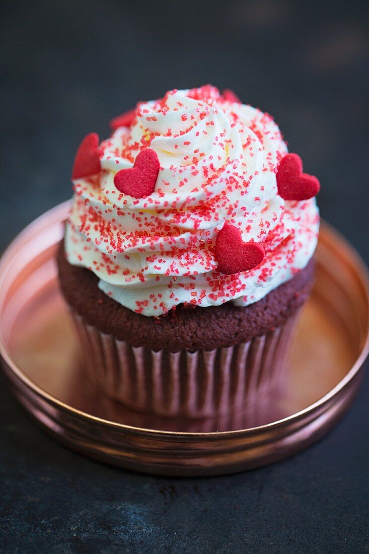 A ret velvet cupcake with vanilla frosting for Valentine's Day