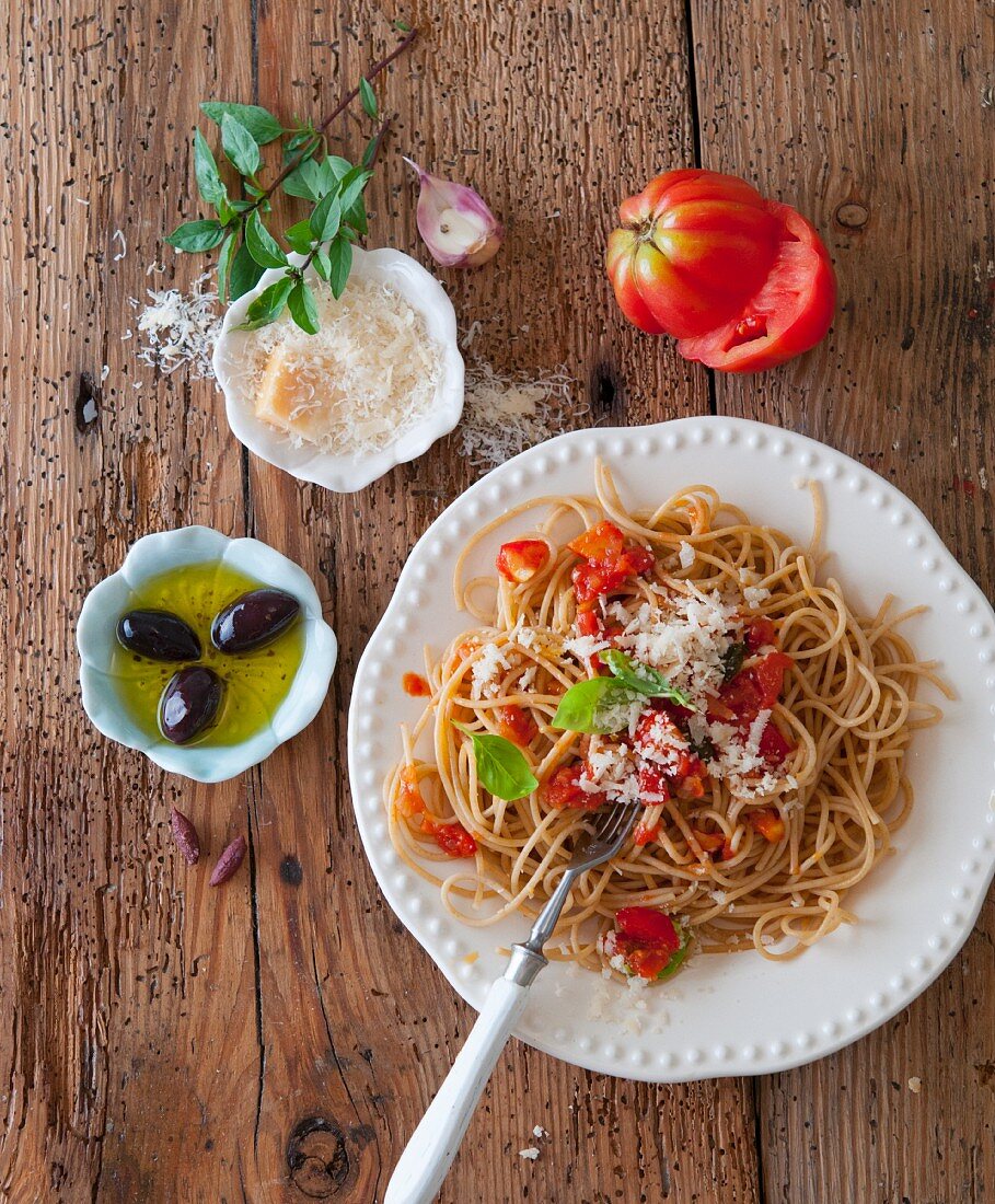 Wholewheat spaghetti with tomato, Parmesan, olives and basil