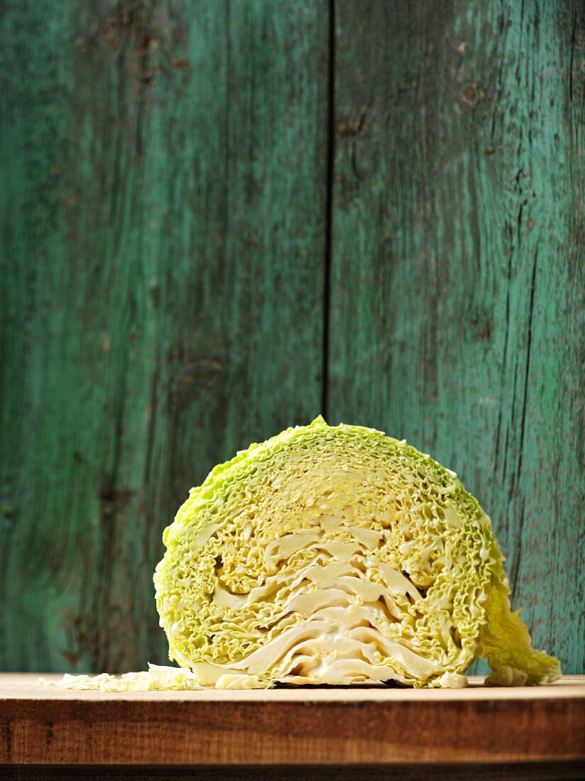 Half a savoy cabbage on a wooden board