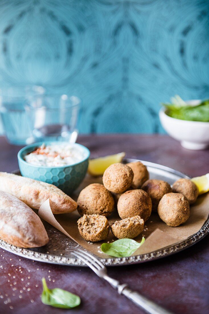 Hausgemachte Falafel mit Tzatziki (Gurken-Joghurt-Dip), Spinat und Fladenbrot