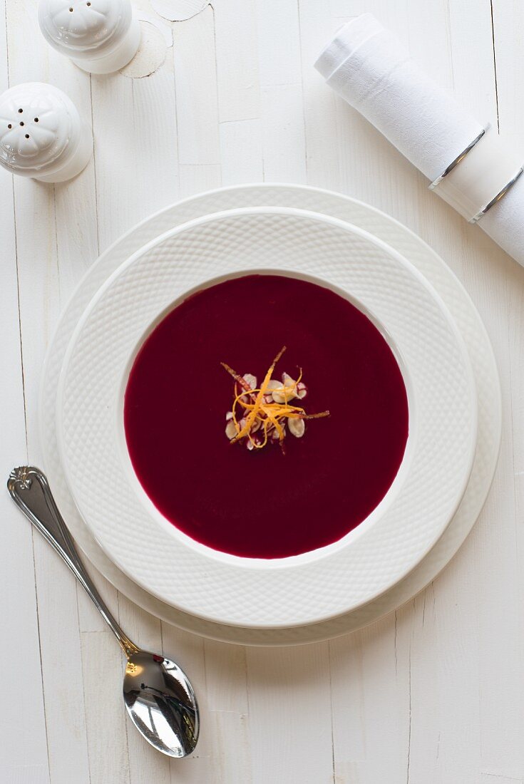 Borscht (beetroot soup) with almond flakes and orange zest