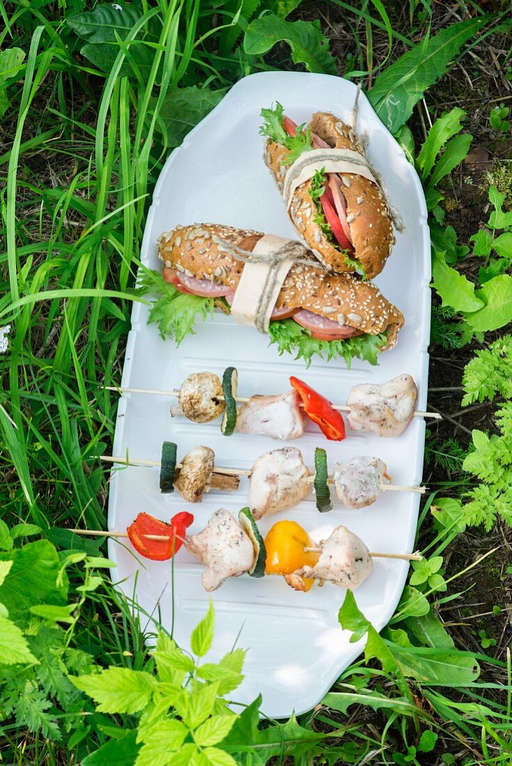 Hähnchen-Gemüse-Spiesse und Salami-Sandwiches für ein Picknick