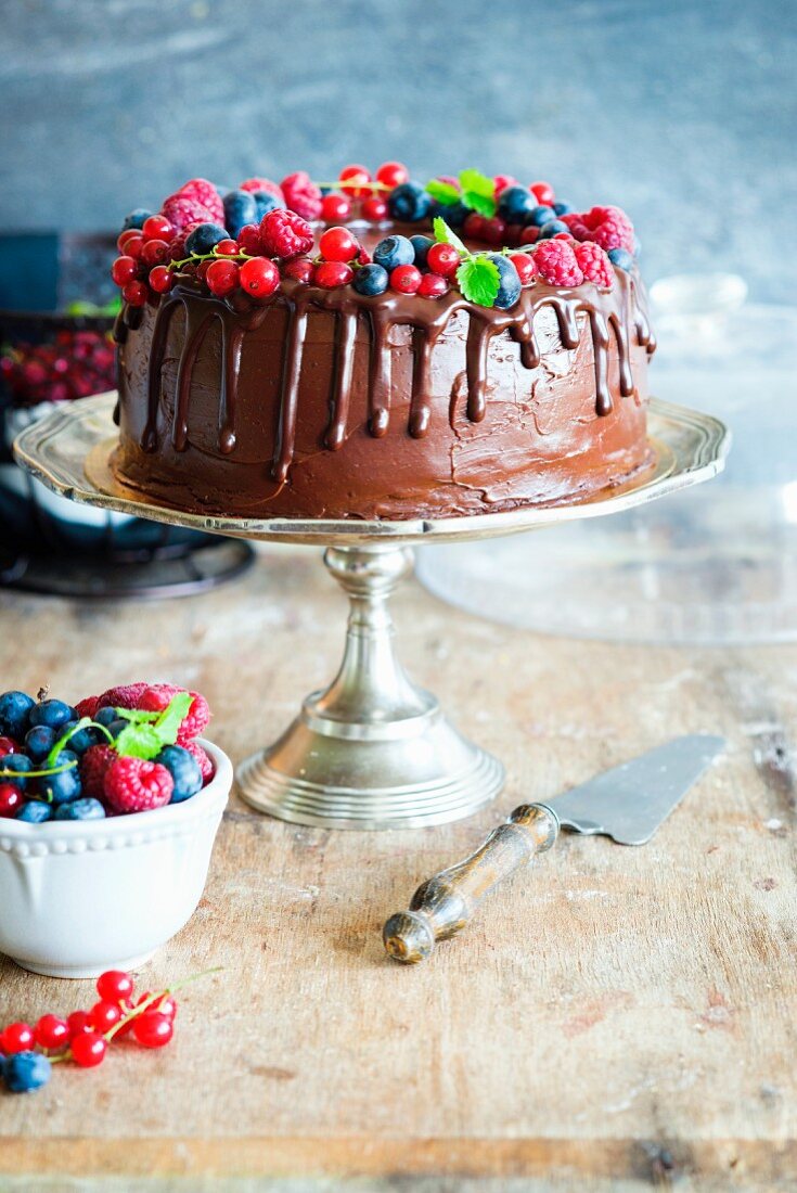 Chocolate cake with chocolate buttercream decorated with fresh berries and mint