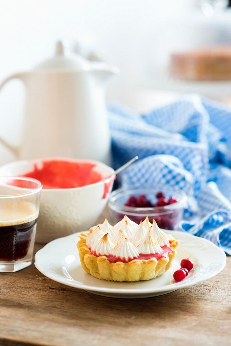 A small tart with a cranberry filling and meringue topping