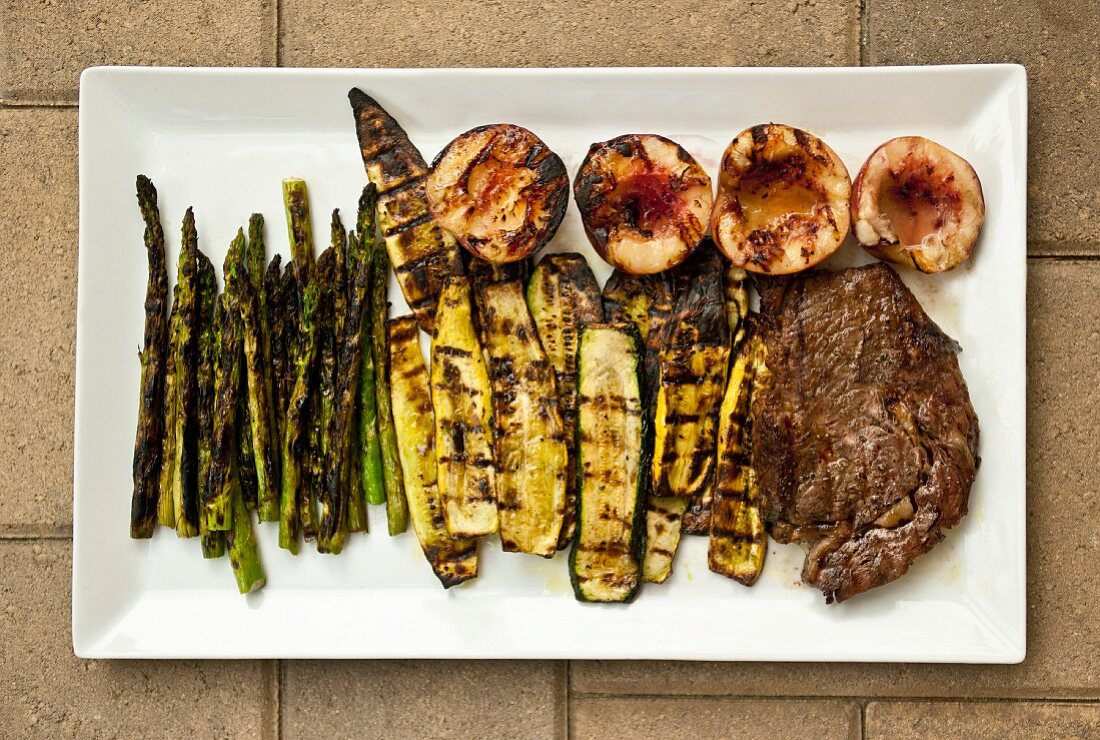 Grilled steak and vegetables on a rectangular plate