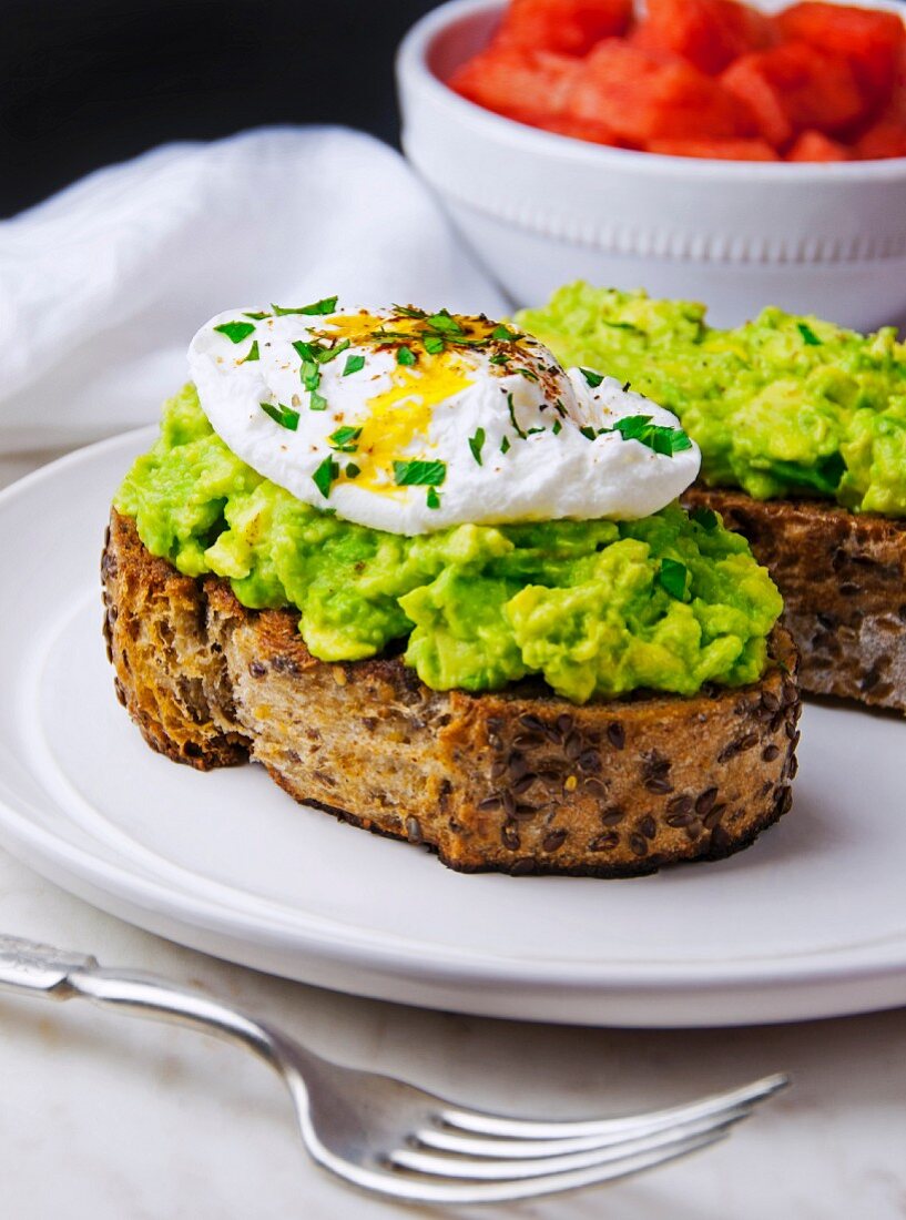 Toasted multi-grain bread topped with avocado purée and a poached egg