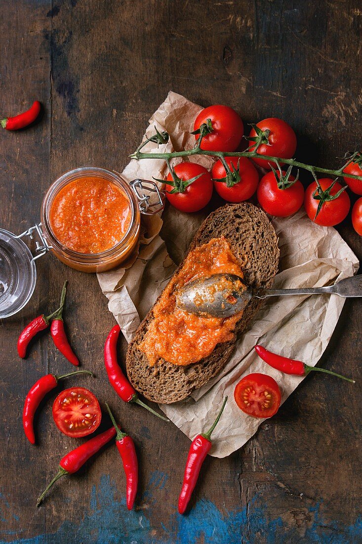 Selbstgemachte Sauce aus Tomaten, roten Paprika, Chilischoten und Schafskäse auf Roggenbrot und im Glas