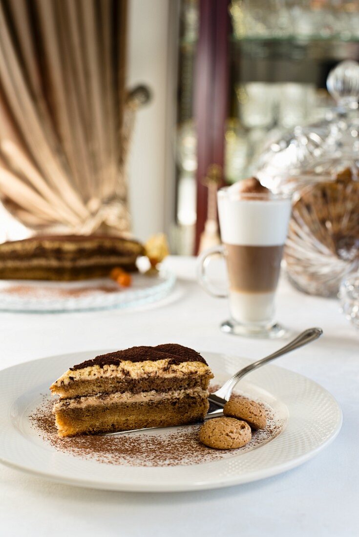 Tiramisutorte aus Biskuit, Mascarponemousse, Kaffee und Kakaopulver, serviert mit Mandelbiscotti