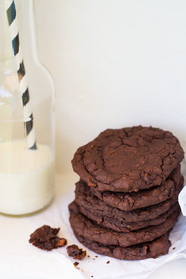 Chocolate cookies made of beans next to a bottle of milk