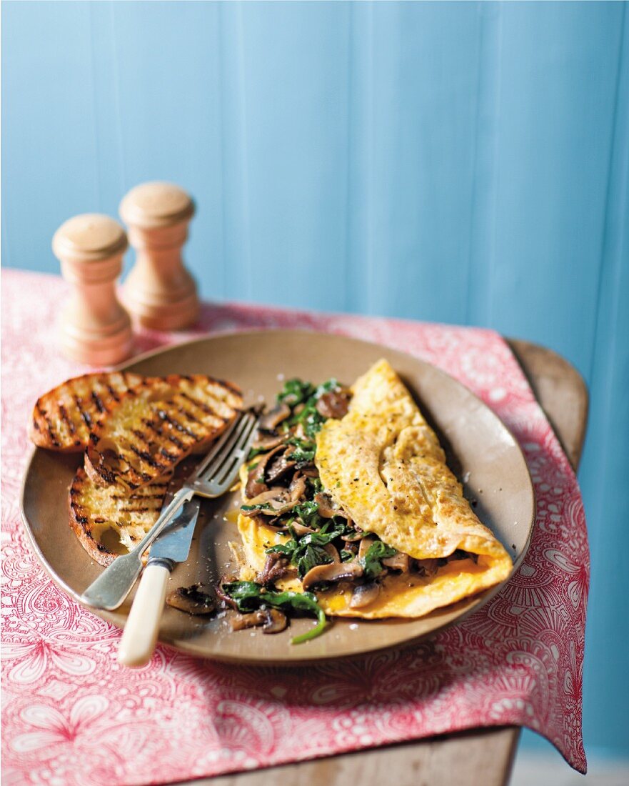 An omelette with mushrooms, baby leaf spinach and truffle oil