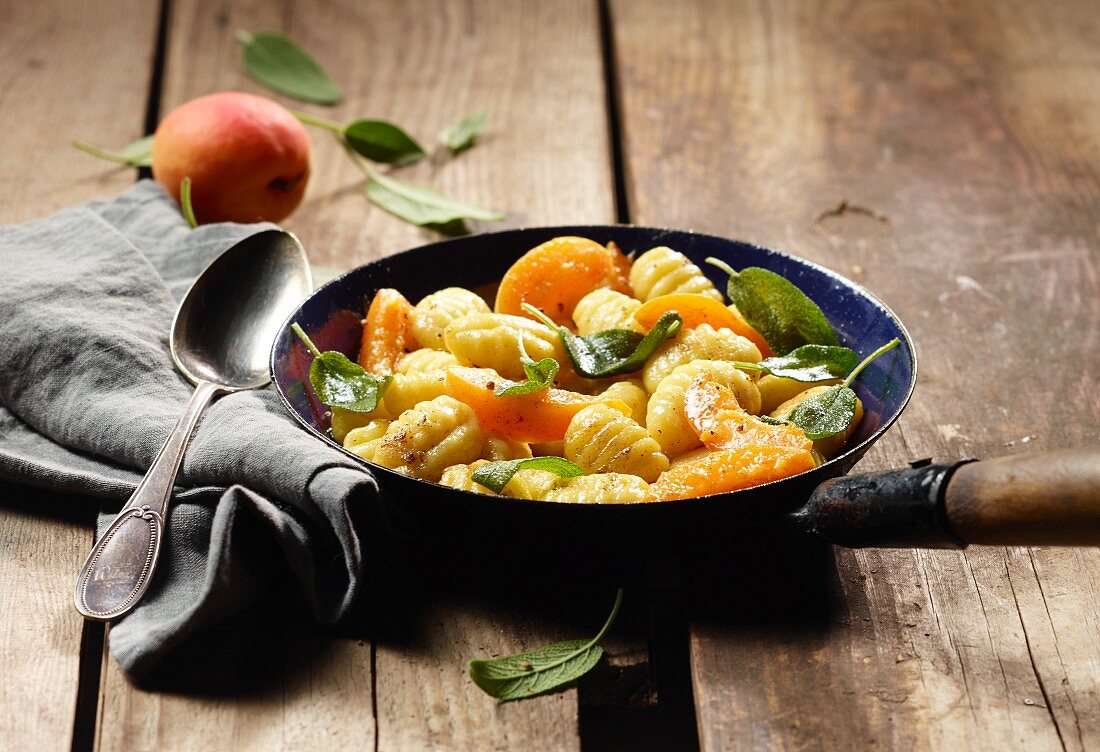 Gnocchi with apricots and sage in a frying pan