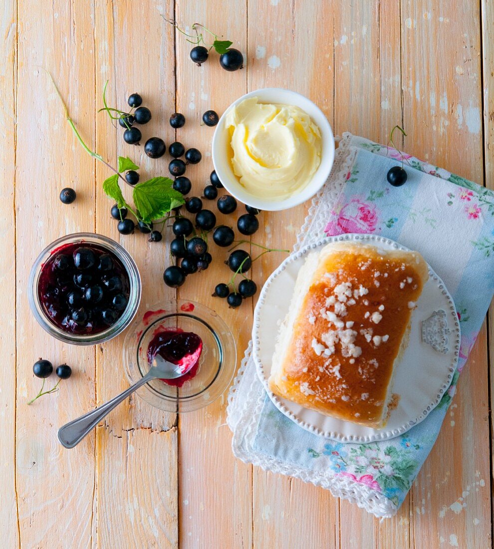 A sweet bun with butter and blackcurrant jam